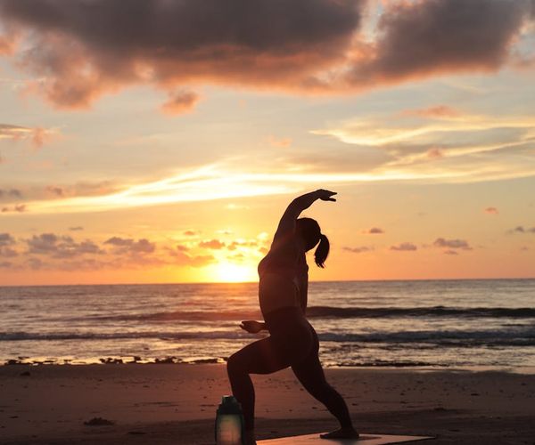 Silhouette of a person stretching during sunrise.